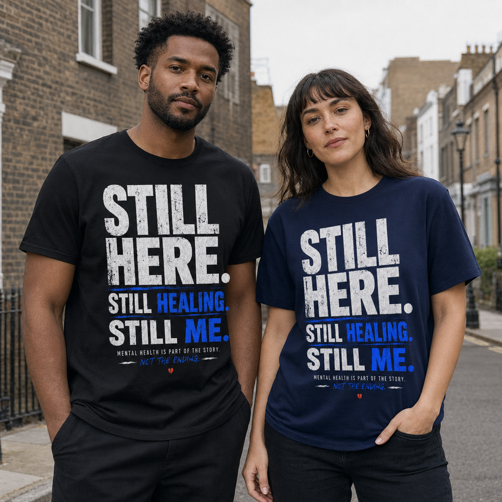 Two adults wearing the Black and Navy Still Here mental health T-shirts